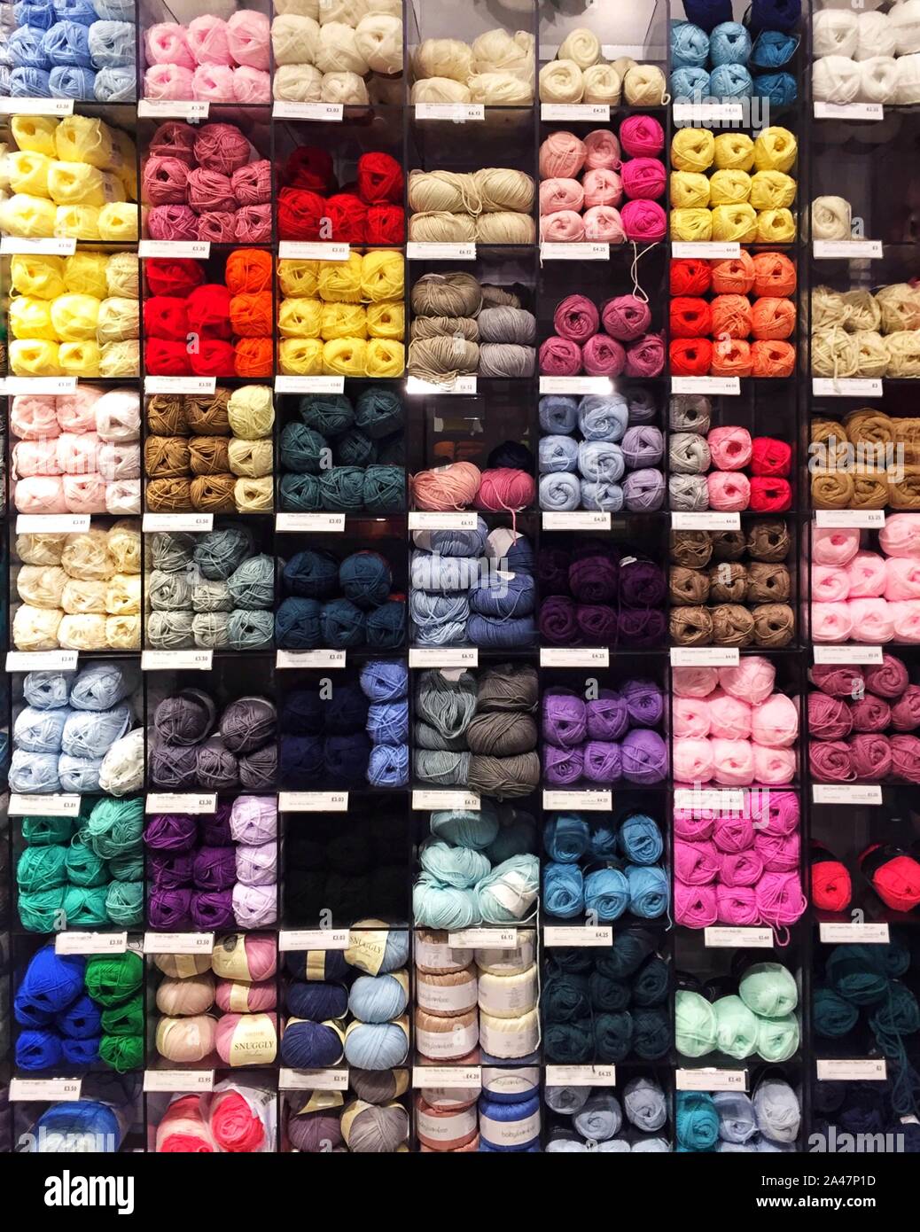Die Regale eines Kurzwarenladens voller bunter Wolle und Garn Stockfoto