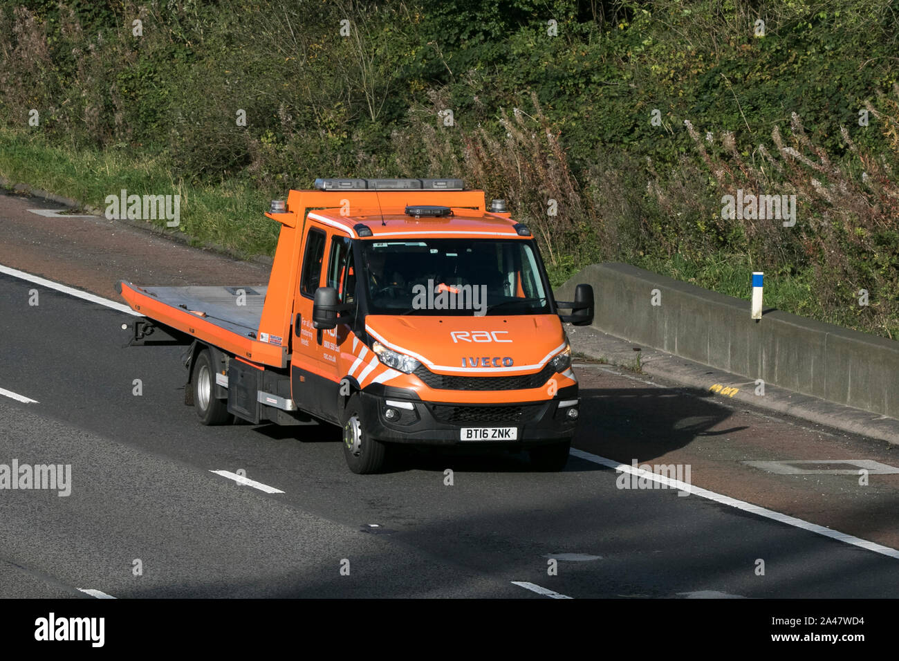 Ein Iveco RAC Flachbett Fahrzeug Pannenhilfe Lkw Position in Richtung Süden auf der Autobahn M6 in der Nähe von Preston in Lancashire, Großbritannien Stockfoto