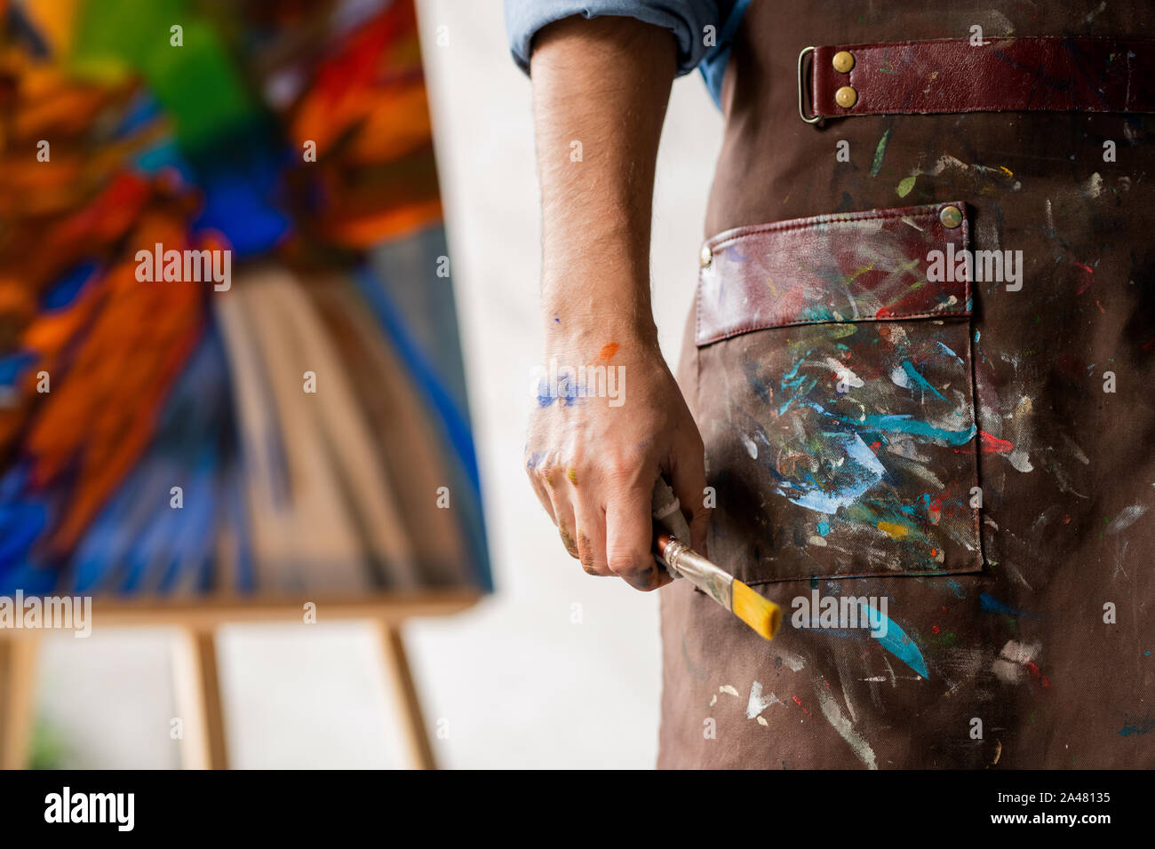Teil der professionellen Maler in schmutzigen Schürze Pinsel in der Hand halten Stockfoto