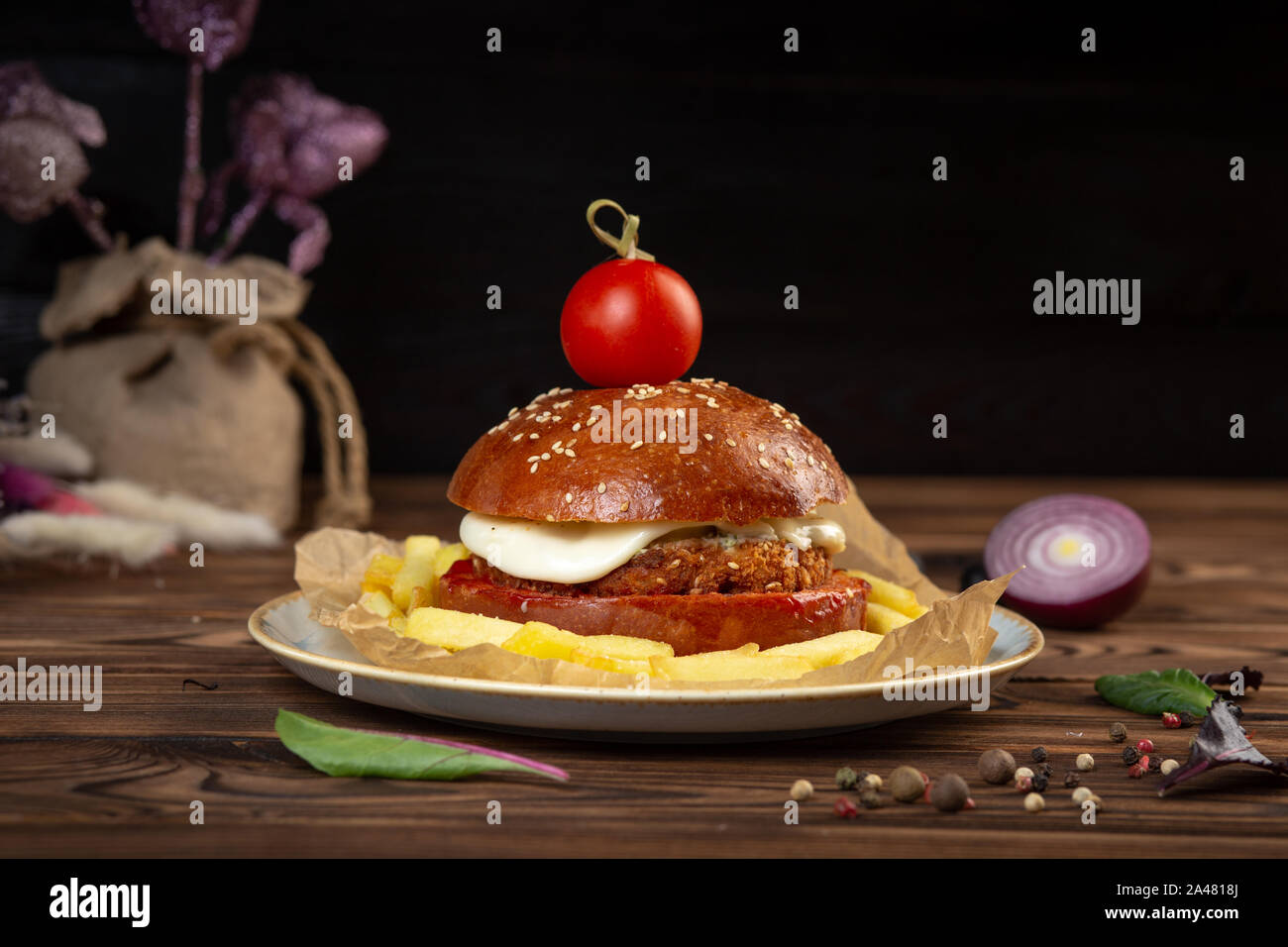 Cheeseburger aus gehacktem Rindfleisch Schnitzel mit Tomaten. Der dunkle Hintergrund. Close-up. Stockfoto