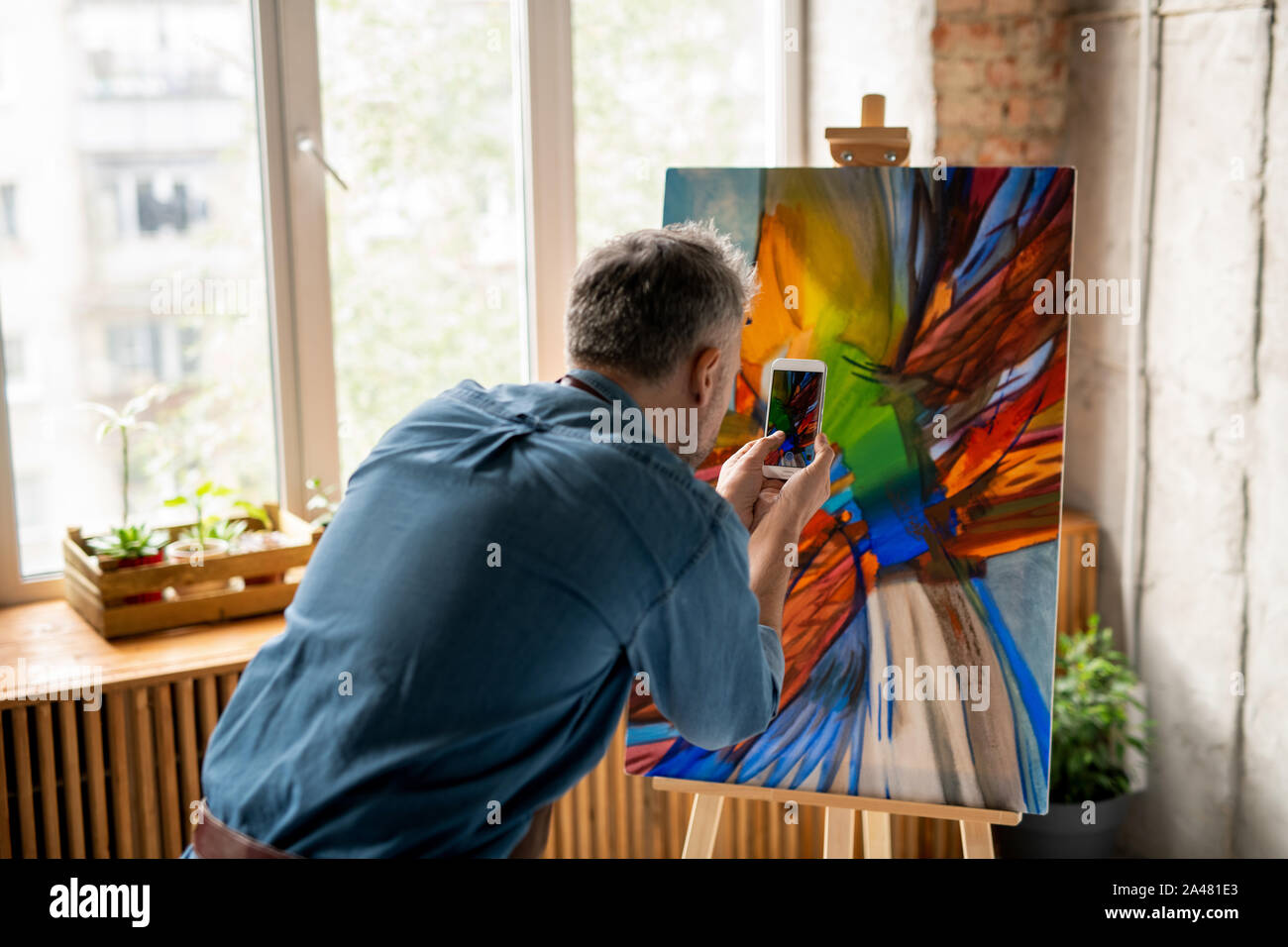 Der heutige Mensch mit Smartphone machen Fotos der Malerei auf staffelei Stockfoto