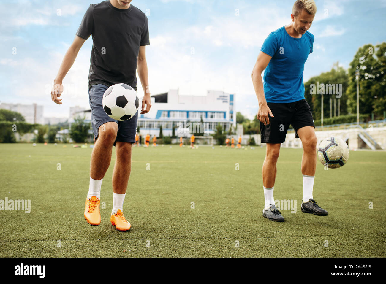 Männliche Fußballspieler stopft den Ball mit den Füßen Stockfoto