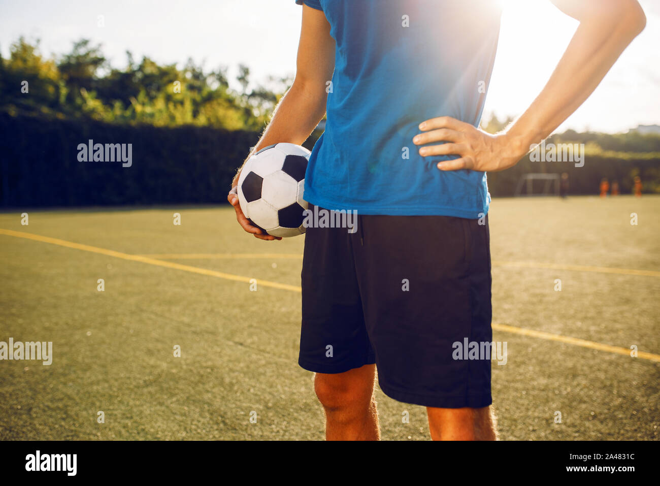 Männliche Fußballspieler mit Ball stehend auf dem Feld Stockfoto