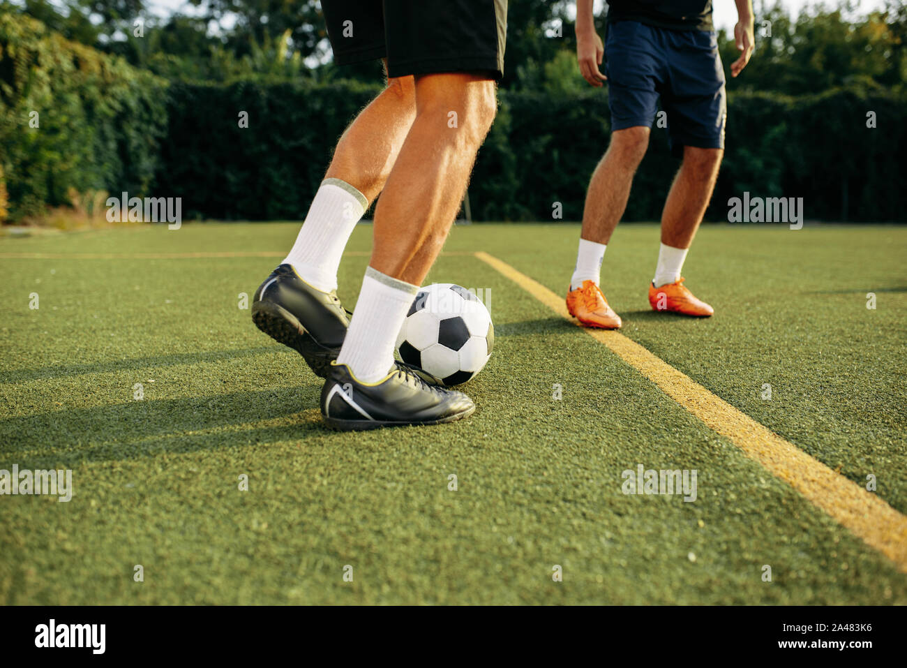 Männliche Fußball-Spieler spielen mit Kugel auf Linie Stockfoto