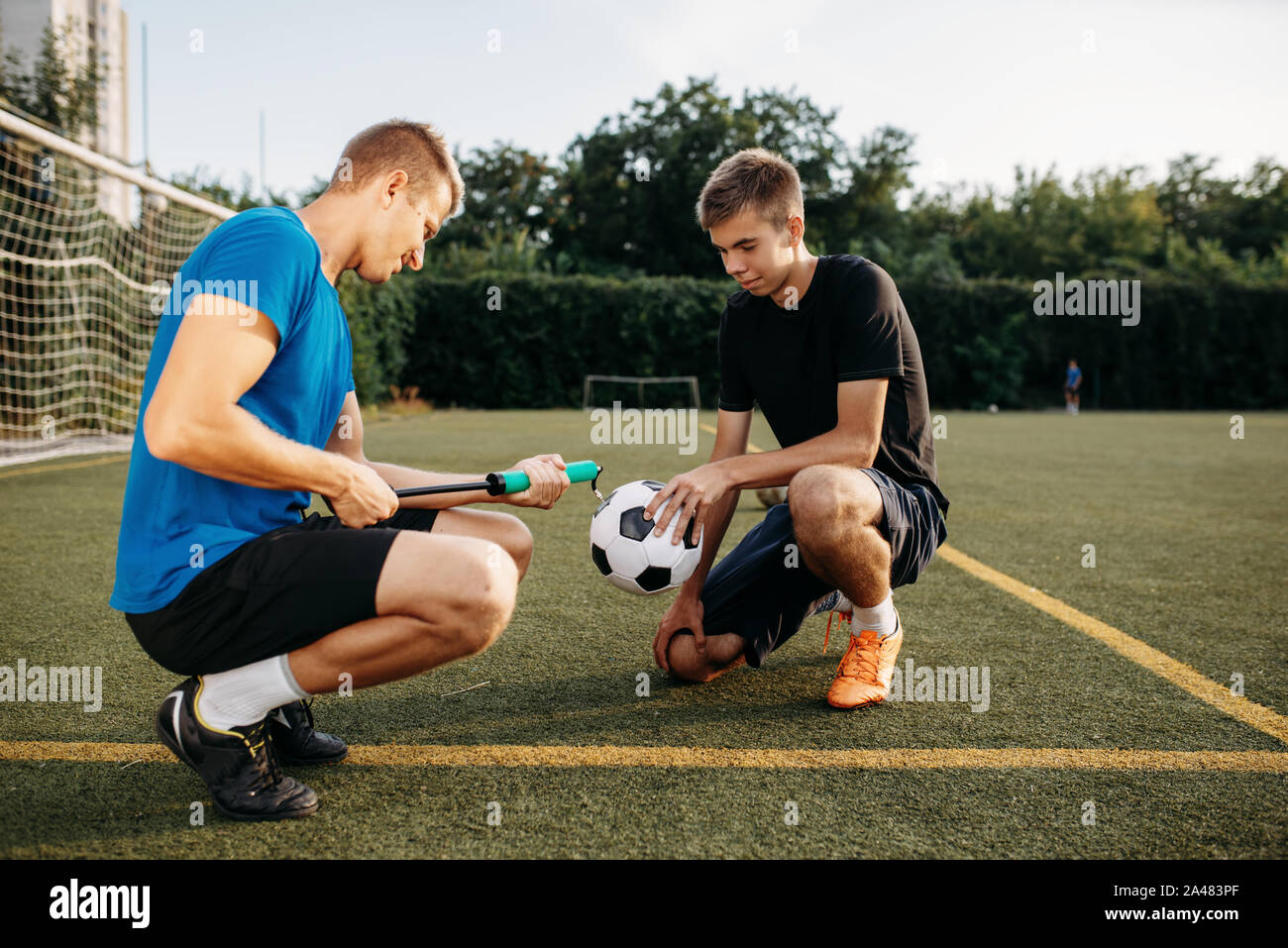 Männliche Fußballspieler Pumpe den Ball auf dem Feld Stockfoto