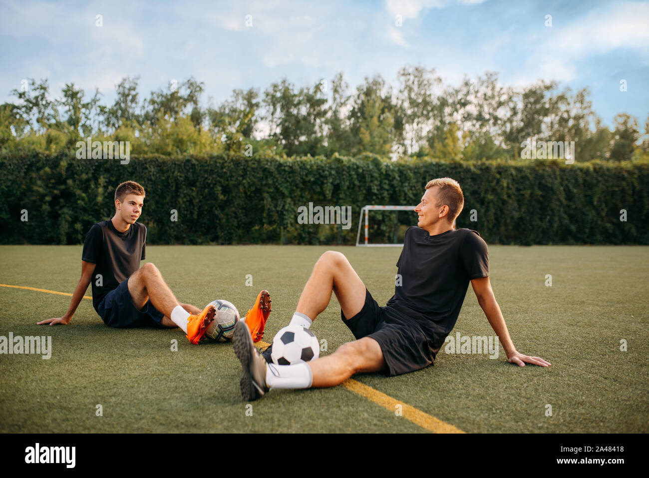 Zwei männliche Fußballspieler ruht auf dem Gras Stockfoto