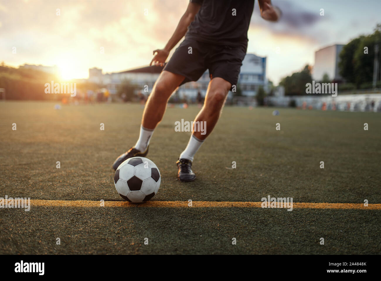 Männliche Fußballspieler schlägt die Kugel auf dem Feld Stockfoto