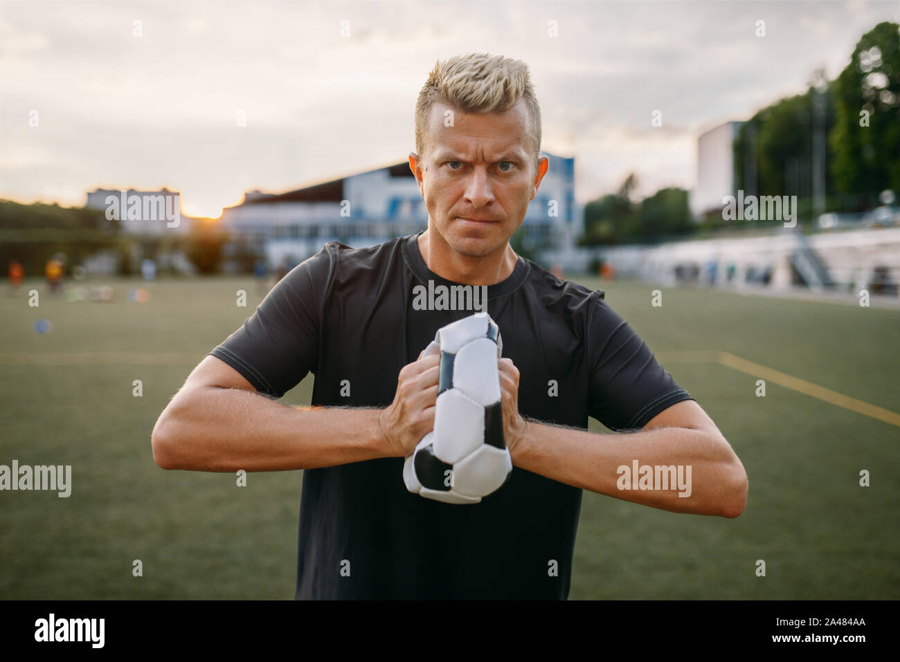 Bösen männlichen Fußball-Spieler den Ball zerknittert Stockfoto