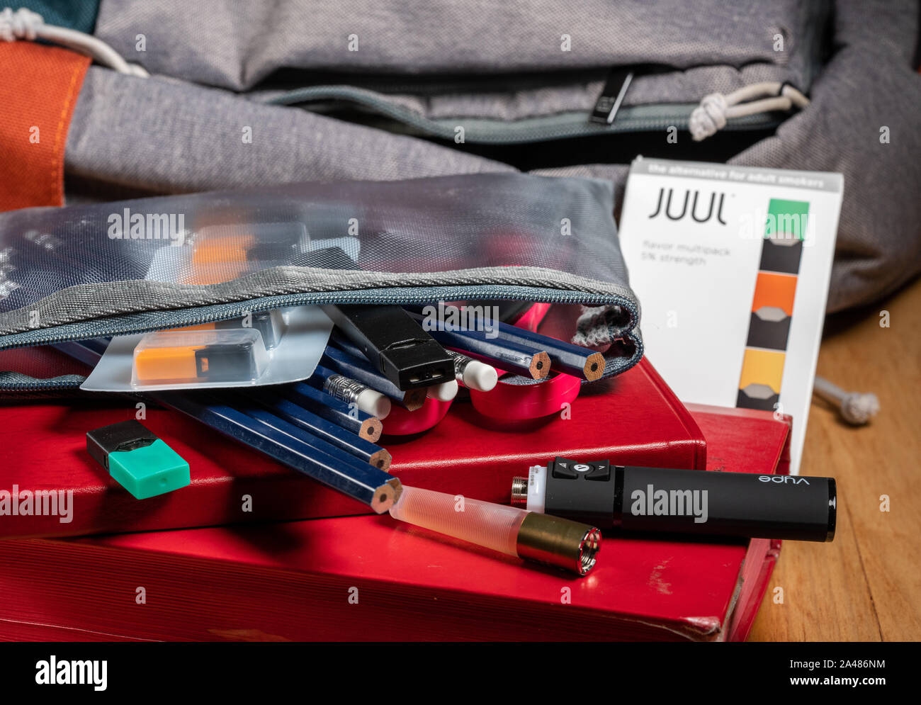 MORGANTOWN, WV - 12. Oktober 2019: Juul Nikotin Dampf Stick und JUULpods mit Vype vaper in Federmäppchen auf Schule Rucksack Stockfoto