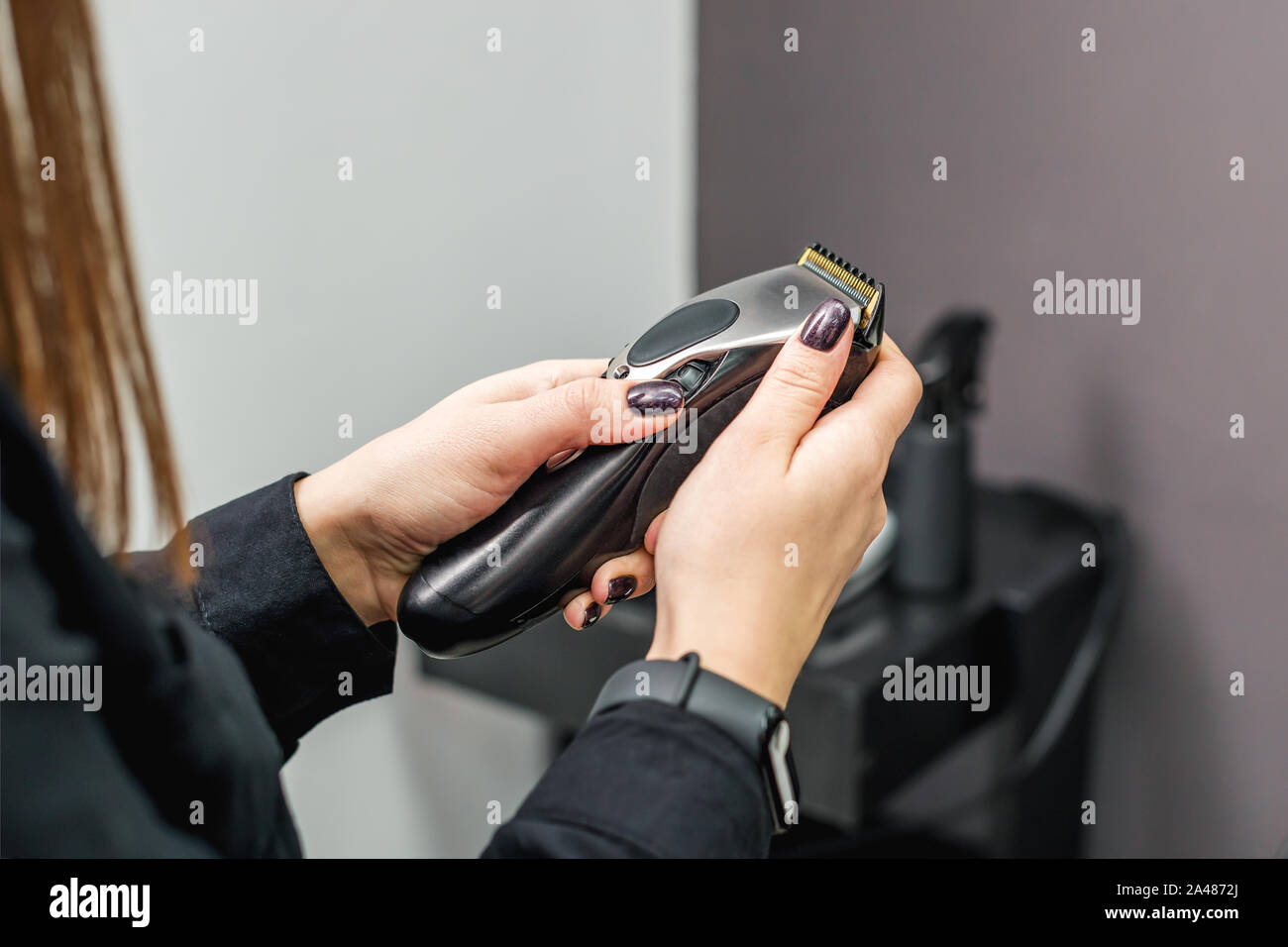Bartschneider Maschine für Frisuren in die Hände der Friseur. Woman's Hand  hält einen Haarschneider Maschine auf dem Hintergrund der Friseur  Stockfotografie - Alamy