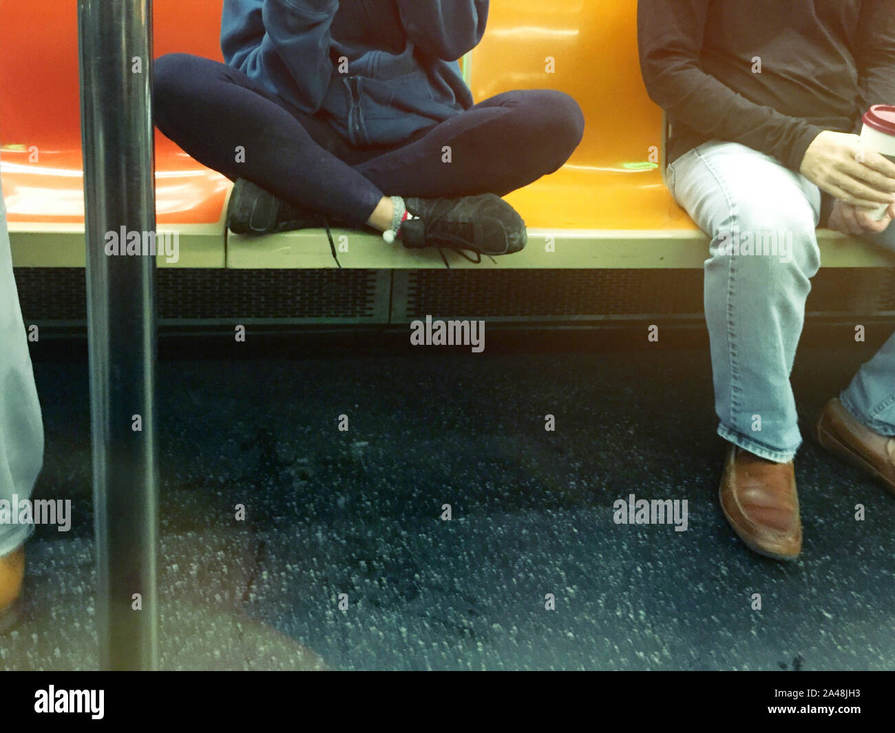 Junge Frau, die mehr als einen Sitz in der New York City U-Bahn (U-Bahn), NYC, USA, belegt Stockfoto