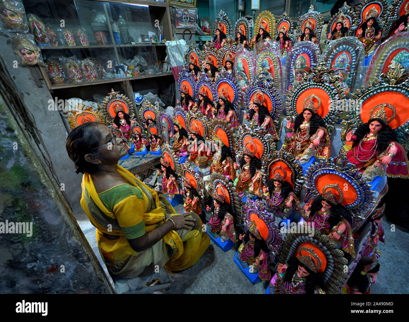 Kolkata, Indien. 12 Okt, 2019. Eine Frau, die Künstlerin mit ihren Kreationen sitzt für den Verkauf Zweck vor Lakshmi Puja Festival in Kalkutta. Kozagari Lakshmi puja hauptsächlich durch die bengalische Durgapuja Hindus verehrt nach. Lakshmi ist die Göttin des Reichtums als Pro der hinduistischen Mythologie und wird von Haus nieder, in der Hoffnung auf Wohlstand, der durch die Hindus zu Haus. Credit: SOPA Images Limited/Alamy leben Nachrichten Stockfoto