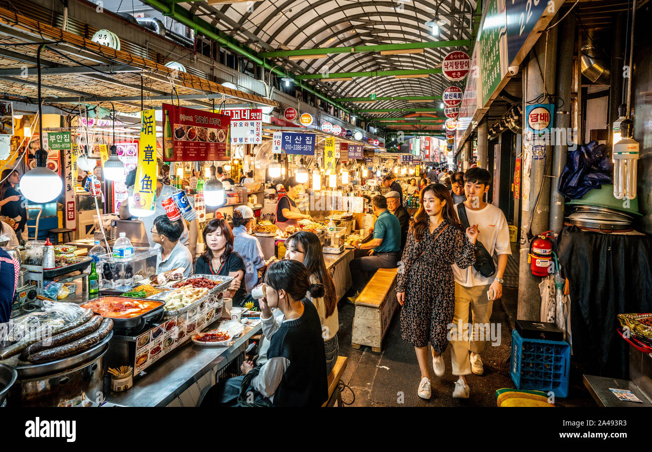 Seoul Korea, 21. September 2019: Blick auf eine Gasse der Kwangjang Markt bei Nacht mit Menschen essen Essen an Ständen Stockfoto