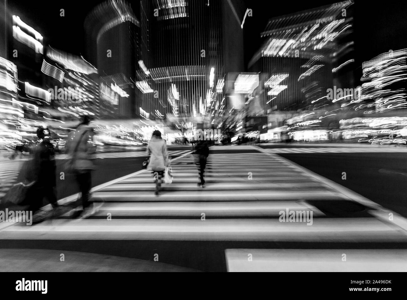 Fußgänger überqueren der Straße im Herzen von Ginza in Tokio. Ginza Kreuzung bei Nacht. Verschwommene Bewegung. Stockfoto