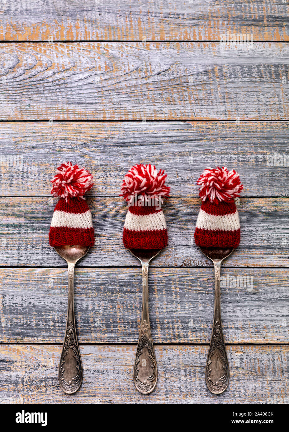 Frohe Weihnachten! Vintage Besteck in Santa Claus Hüte auf alten hölzernen Hintergrund. Hintergrund mit kopieren. Stockfoto