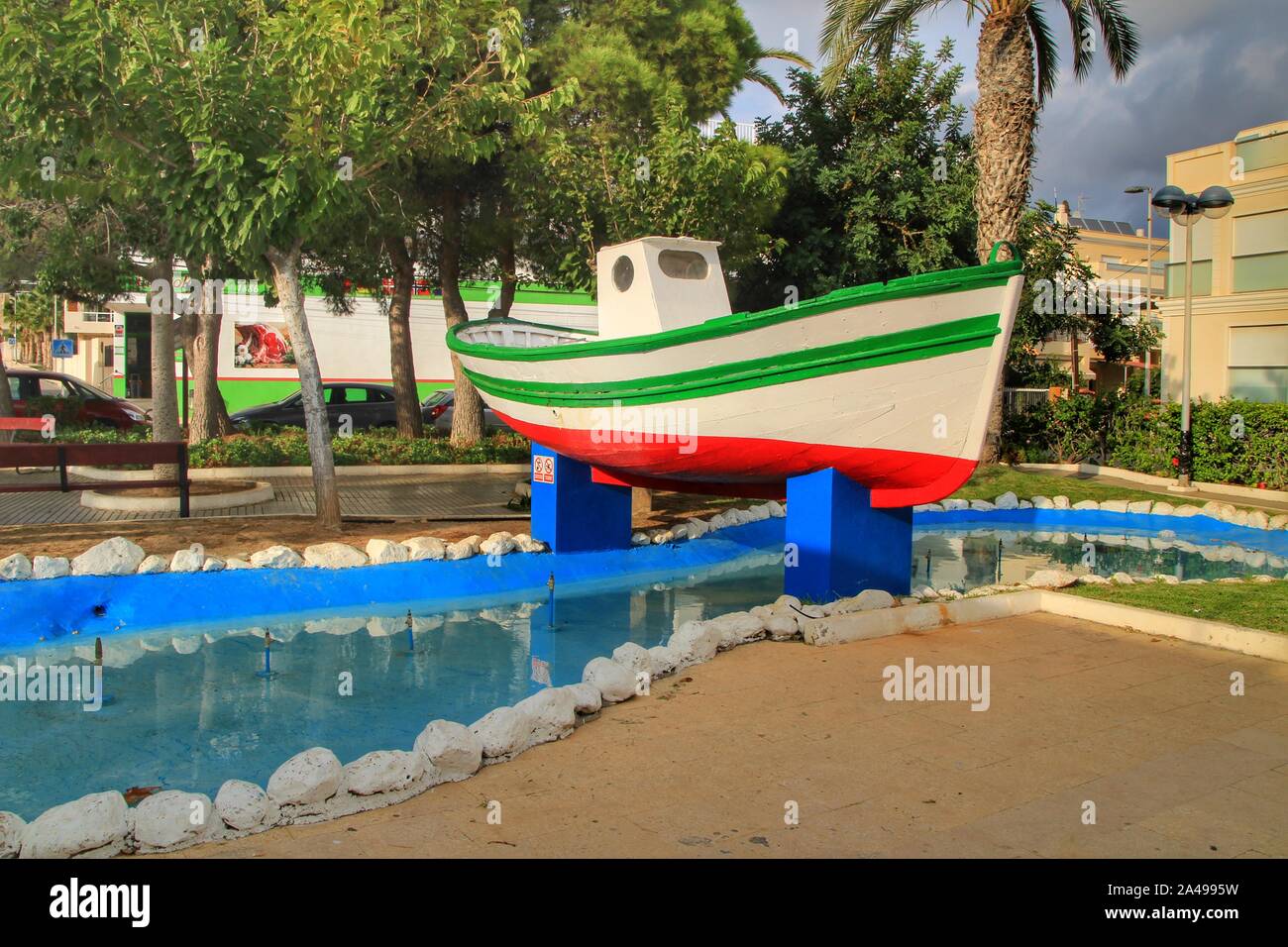 Isla Plana, Murcia, Spanien - Oktober 7, 2019: Bunte Fischerboot von Vegetation und ein Brunnen auf dem Hauptplatz von Isla Plana Dorf umgeben Stockfoto