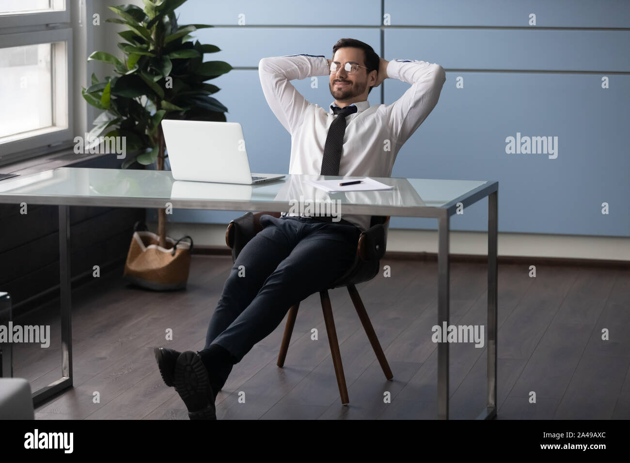 Zufriedene junge männliche Manager genießen Pausenzeit. Stockfoto