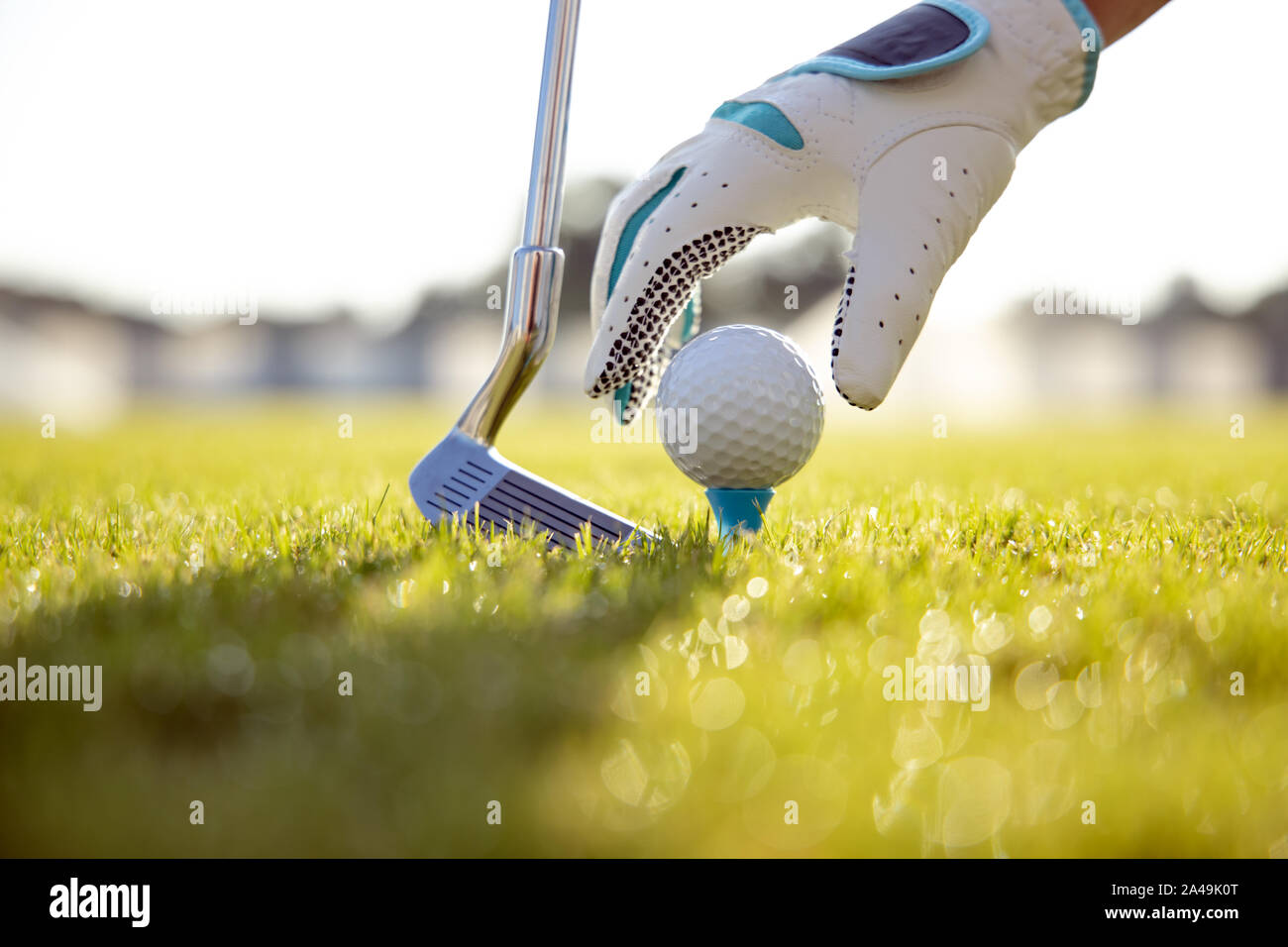 Hand in Hand platzieren Golfball auf T-Stück Stockfoto