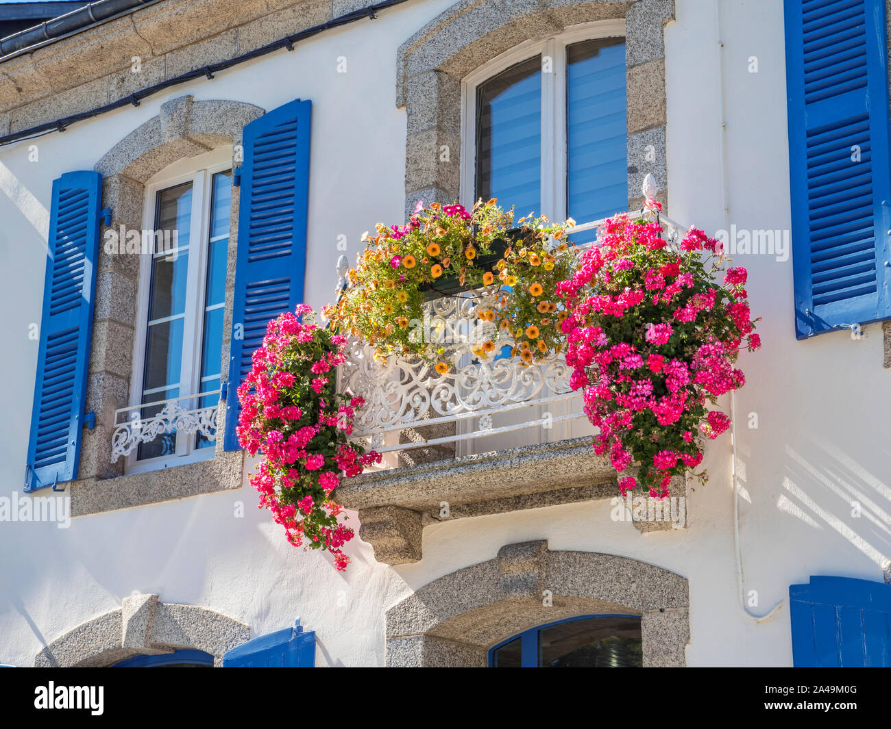 PONT AVEN Gite de France Zimmer mit üppigem bunten Balkon mit Blumenblumen und traditionellen blauen Fensterläden Pont Aven Bretagne France Stockfoto