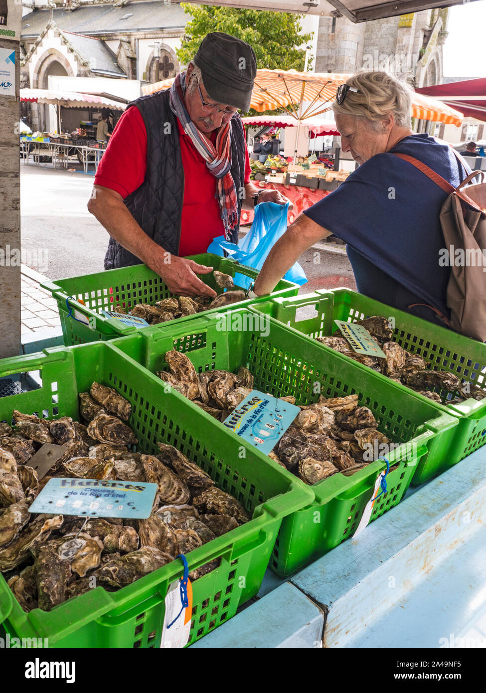 Austern SHOPPER BRETAGNE MARKT Moëlan-sur-Mer wöchentlich Fischmarkt in der Kirche Platz ausgeht, mit frischen Austern Auswahl und anspruchsvollen Kunden Kunden ihre Wahl aus einer Vielzahl von Oyster Container Stockfoto