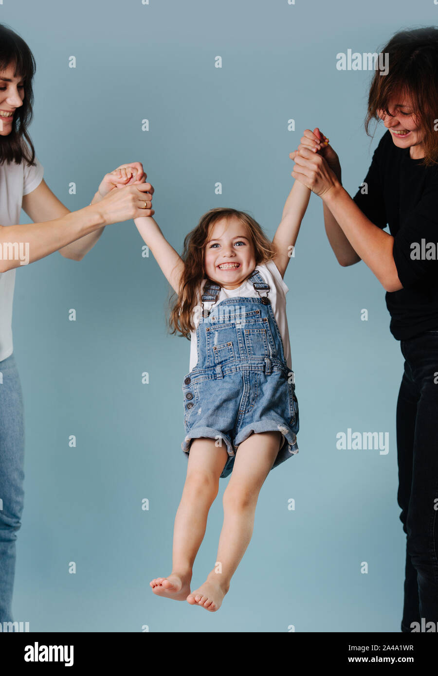 Zwei Frauen schwingen Toddler girl Holding ihre Hände Stockfoto