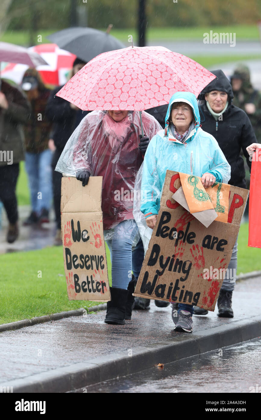 Menschen März in der Nähe der Parlamentsgebäude, Stormont in Belfast, das Wahrzeichen von 1.000 Tage seit der dezentralisierten Institutionen zusammen. Stockfoto