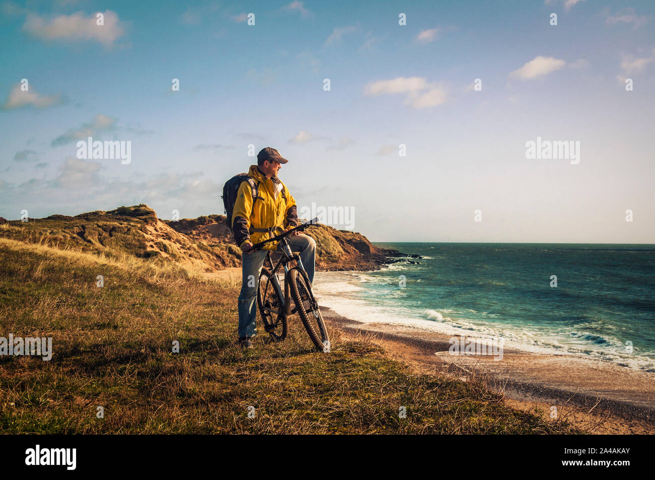 Radfahren in Irland. Freizeit Radfahrer mit Mountain Bike und Rucksack am Rande der Dünen mit Blick auf das Meer. Stockfoto