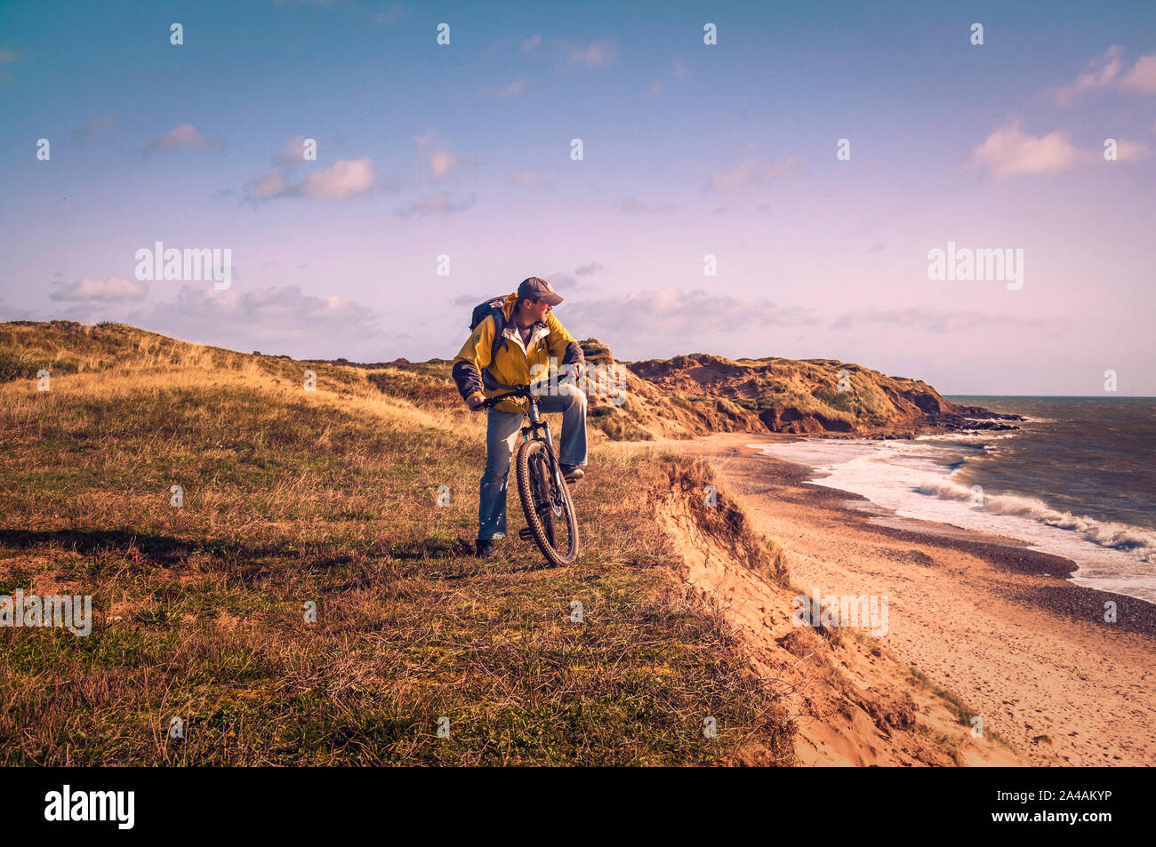 Radfahren in Irland. Freizeit Radfahrer mit Mountain Bike und Rucksack am Rande der Dünen mit Blick auf das Meer. Stockfoto