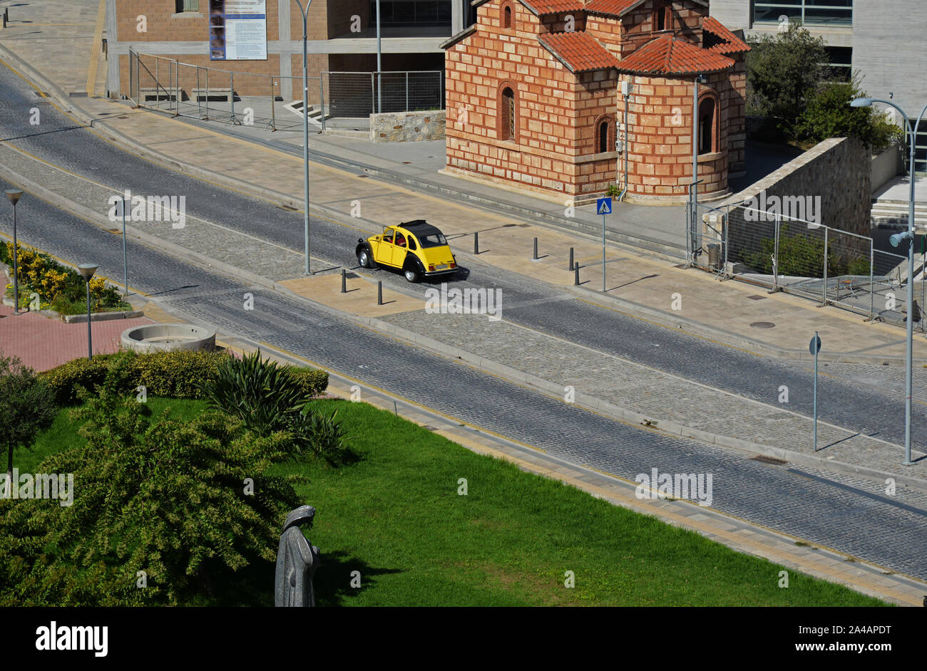 Gelbe Citroen 2 CV Oldtimer mit Schiebedach über einen Zebrastreifen in Heraklion, Kreta, Griechenland. Stockfoto