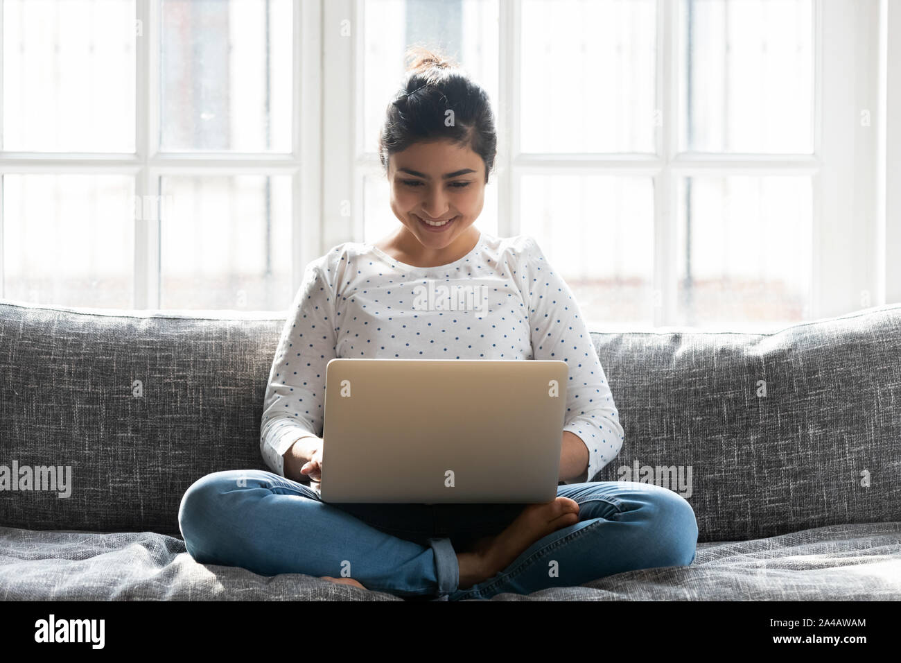 Lächelnd indische Frau mit Laptop, chatten, im sozialen Netz Stockfoto