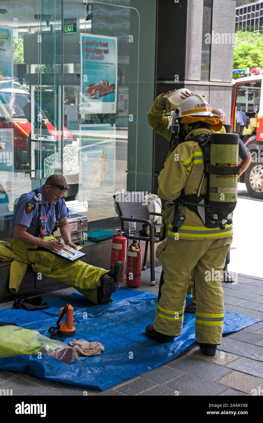 Mitglieder des Queensland Feuer- und Rettungsdienst Teilnahme an einem Bürogebäude, wo ein starker Geruch von Benzin Dämpfe war in Brisbanes schlimmsten entdeckt Stockfoto