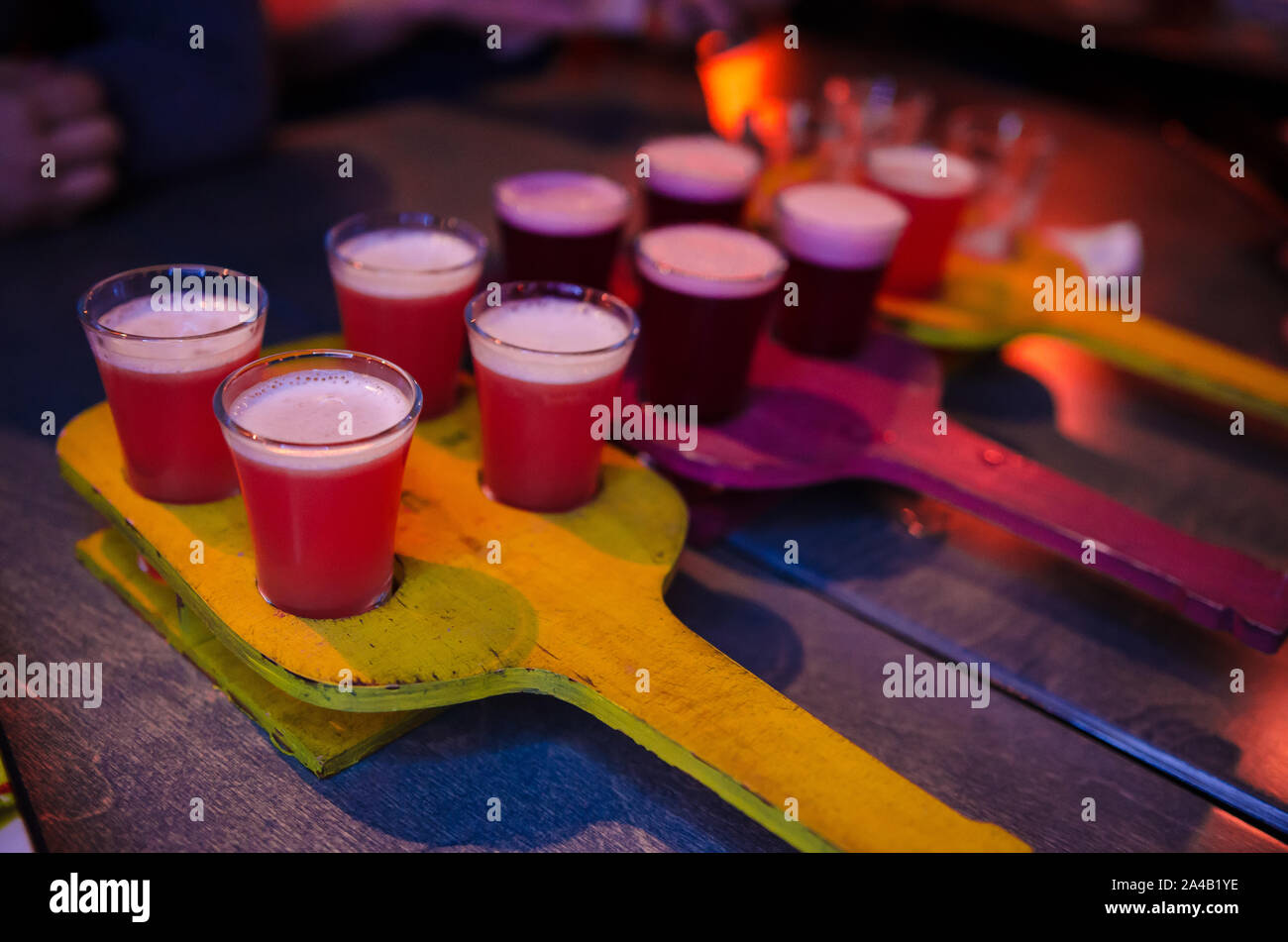 Rot transparent Cocktails, eine Reihe von Aufnahmen in einer Zeile. Vier Portionen auf einem Stand aus Holz Stockfoto