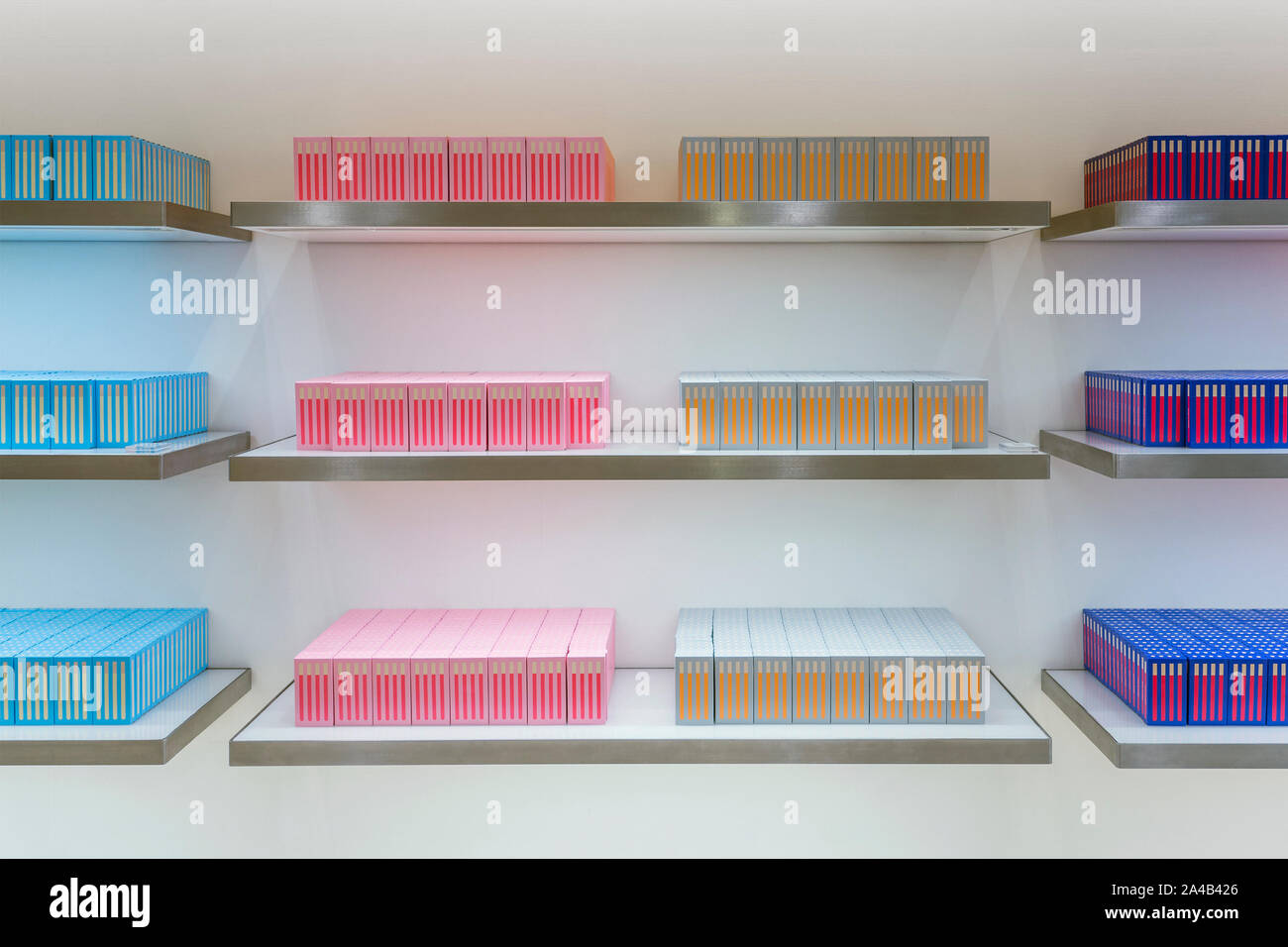Volle Regal von bunten Schachteln. Stapel von Kartons. Anzeige von Reihe Blau, Gelb und Rosa. Stockfoto