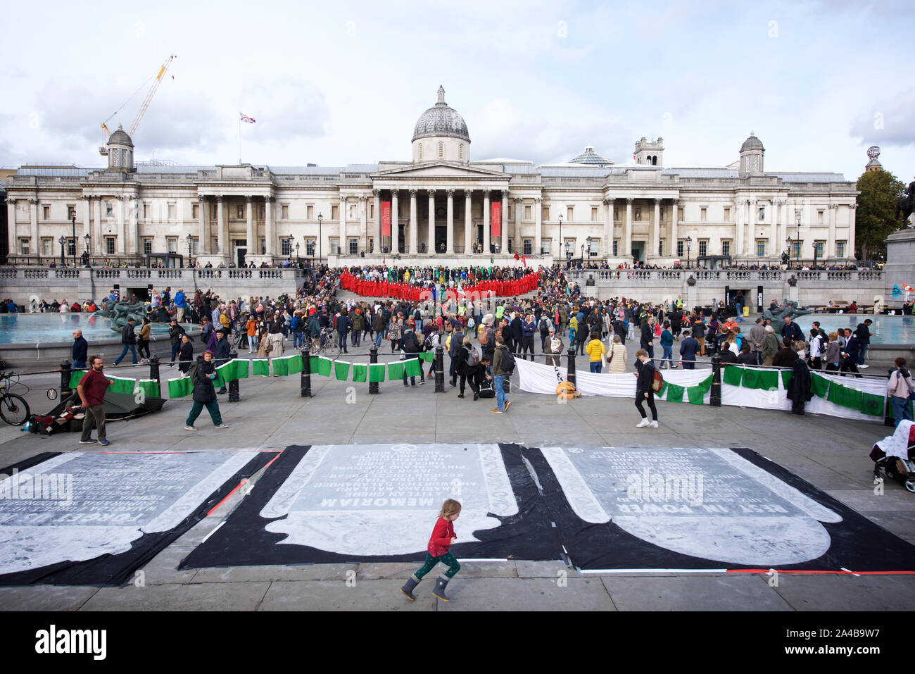 Red Rebel Brigade an der National Gallery, während Priester und Bischöfe wechselten zu lesen das Buch der Offenbarungen. Aussterben Rebellion Protest weiterhin in London ab dem 7. Oktober. Das Ziel der Teilnahme an gewaltfreier direkter Aktion und zivilem Ungehorsam wurde die Aufmerksamkeit auf die Klimakrise und Verlust der biologischen Vielfalt zu zeichnen. Aussterben Rebellion Forderungen sind, dass die Regierungen die Öffentlichkeit die Wahrheit über das tatsächliche Ausmaß der Krise, jetzt Maßnahmen ergreifen, die CO2-Emissionen zu verringern und, das Bürgerinnen und Bürger Baugruppen Änderungen der Richtlinien zu überwachen. Sie verlangen auch, dass Maßnahmen ergriffen werden, um die einzustellen. Stockfoto