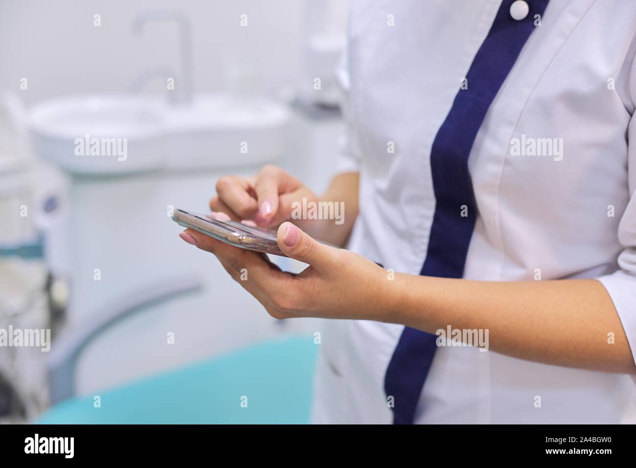 In der Nähe der weiblichen Ärzte hand mit Handy Smartphone, zahnmedizinische Klinik Büro Hintergrund Stockfoto