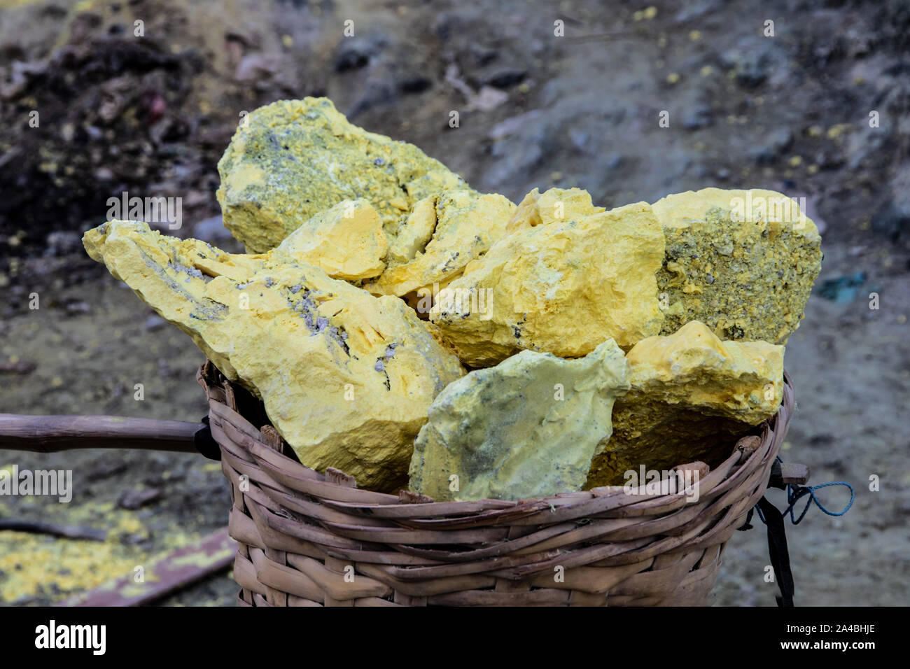 Blöcke von Schwefel in einem Korb, aus vulkanischem gas Lüftungsschlitze in die Kiste des Mount Ijen, Ost Java, Indonesien abgebaut. Gase sind durch Leitungen umgeleitet und die Stockfoto