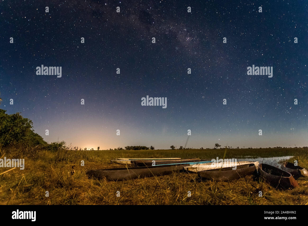 Botswanian lokale mokoro Boote unter der Starlight Himmel, am Ufer des Okavango Delta, Botswana Stockfoto