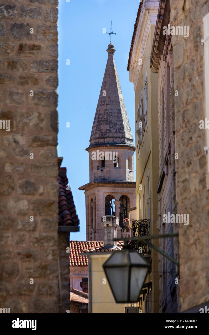 Ansicht des Heiligen Ivan Glockenturm der Kirche von den engen Gassen der Altstadt von Budva, Montenegro Stockfoto