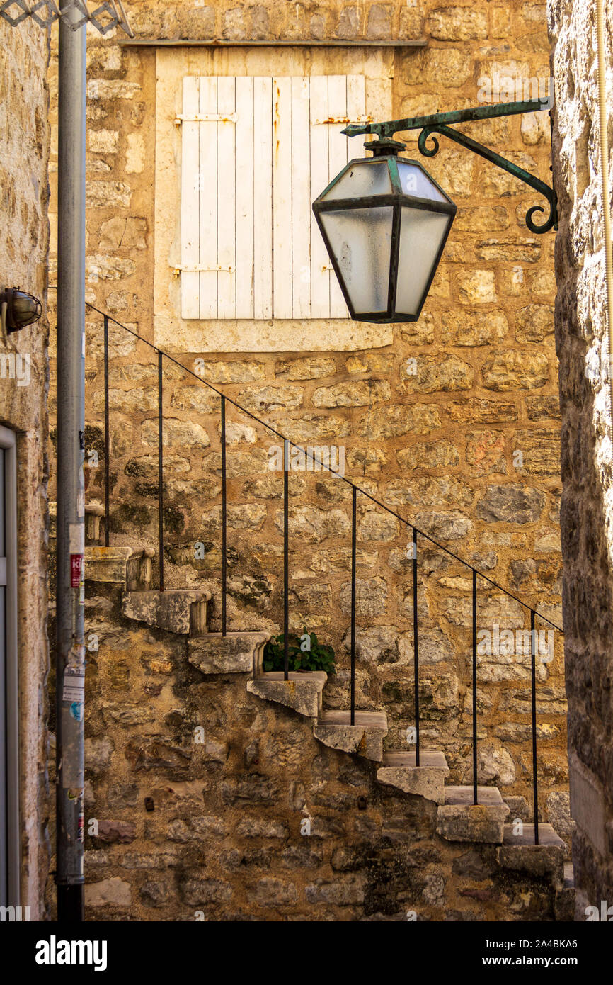 In einer ruhigen Seitenstraße in der Altstadt von Budva, Montenegro ist eine verzierte Treppe Stockfoto