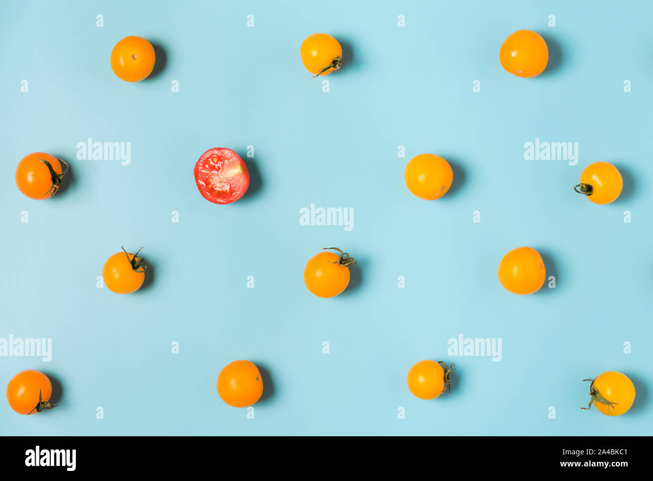 Die Hälfte der roten Tomate Kirsche aus gelben Tomaten Cherry. Individualität und Differenz Konzept. Flach Stockfoto