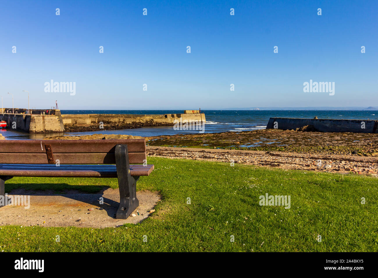 Leeren Parkbank mit Blick auf den Hafen in St. Monans, Schottland Stockfoto