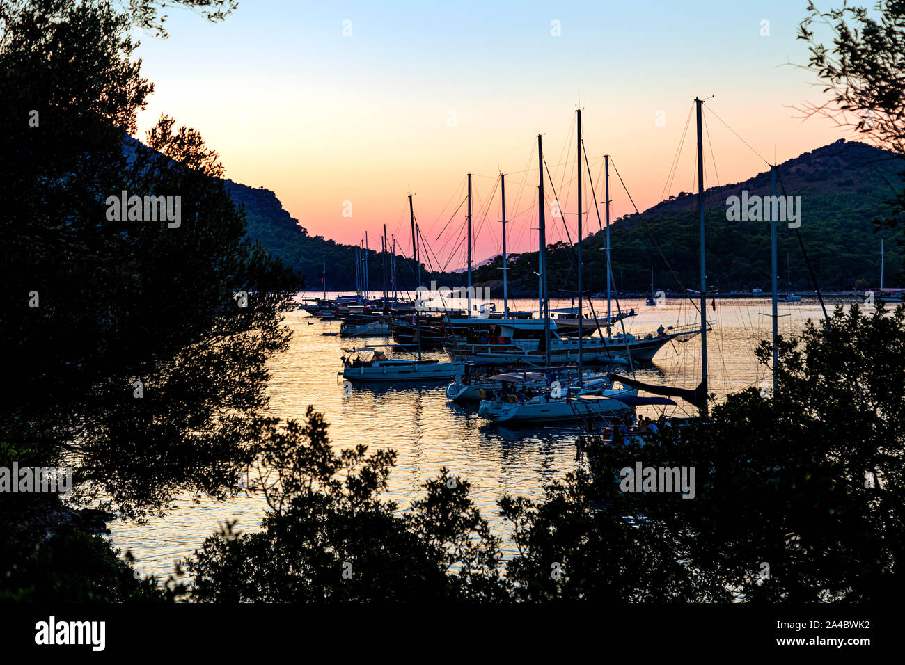 Segelboote von gemiler Insel bei Sonnenuntergang verankert, Türkische Riviera, Türkei Stockfoto