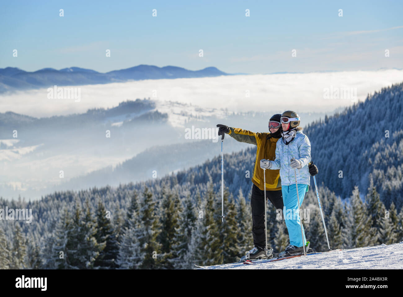 Männliche und weibliche Skifahrer am Hang, ein glückliches Paar Stockfoto