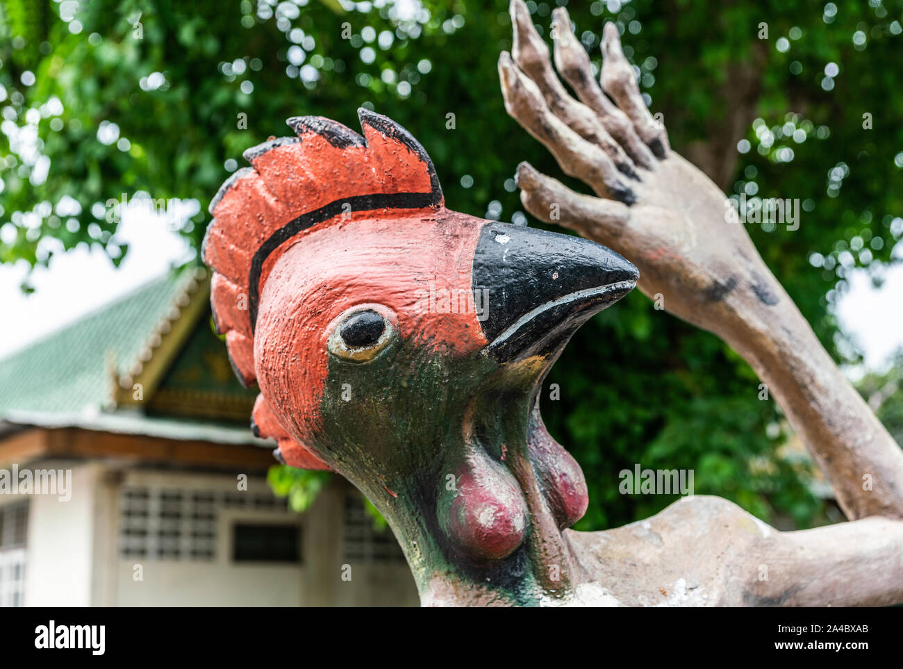 Bang Saen, Thailand - 16. März 2019: Garten der Hölle in Wang Saensuk buddhistischen Kloster. Nahaufnahme der Kopf des Huhns, das für ein folterknecht gegen Grün Stockfoto