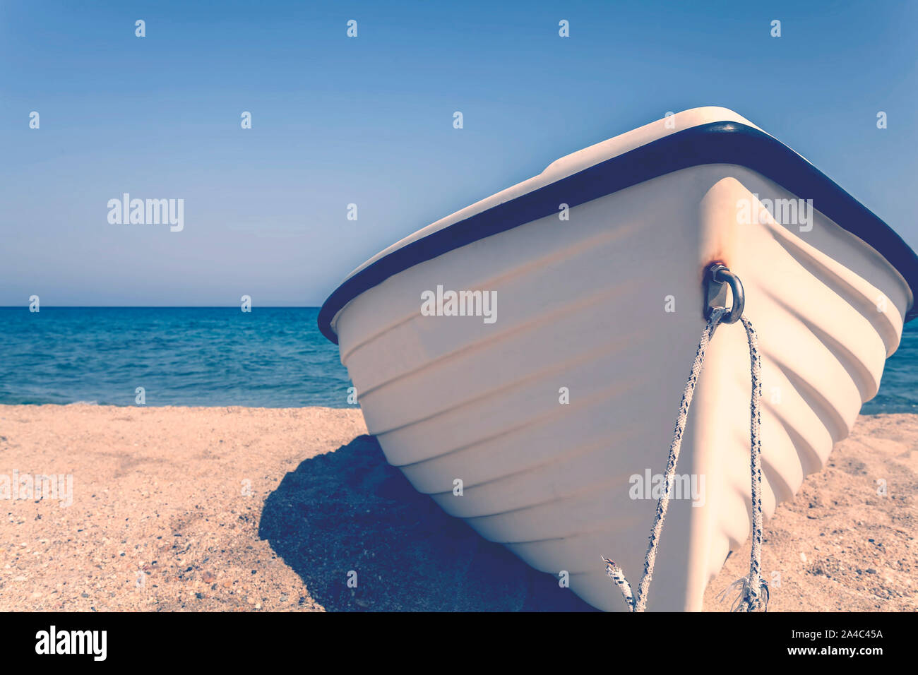 Retro Vintage getönten Fischerboot am Strand mit blauem Himmel und das Meer im Hintergrund Stockfoto