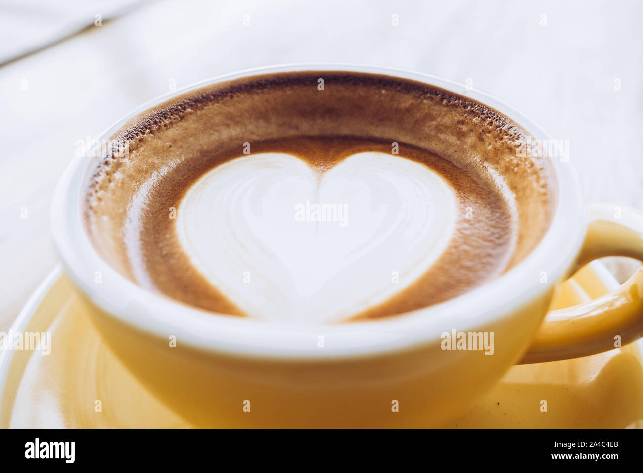 Nahaufnahme heißen Cappuccino Tasse auf Holz- Fach mit Herz latte Kunst auf Holz Tisch im Cafe, Banner Größe Essen und Trinken Konzept. Stockfoto