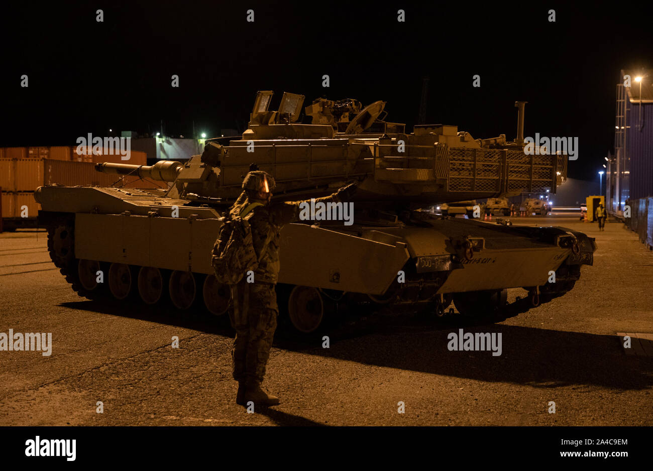 Ein Soldat aus dem 2. gepanzerte Brigade Combat Team, 1.Kavallerie Division, Führer der M1A2 Abrams Panzer der Staging Area als Fahrzeuge werden von einem Fahrzeug Transport Schiff in ganz Europa Okt. 11, 2019 für die Bereitstellung von Entladen im Hafen von Vlissingen, Niederlande. 2. ABCT ist die Auslagerung der erste von drei Sendungen von militärischer Ausrüstung zum Hafen, wie sie sich vorbereiten, rund 3.500 Soldaten und mehrere Radfahrzeuge bereitzustellen, Kettenfahrzeugen, Paladine, Tanks und Anhängern in ganz Europa zur Unterstützung der Atlantischen lösen Demonstration des 2. ABCT Fähigkeit, schnell und entschlossen reagieren zu CRI Stockfoto