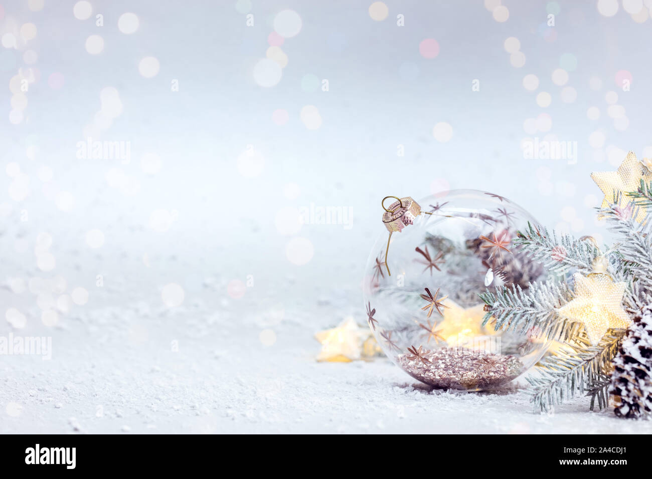 Winter Snowy White Background mit Fir Tree Branch, Glaskugel und glühenden Lichter Girlande Stockfoto