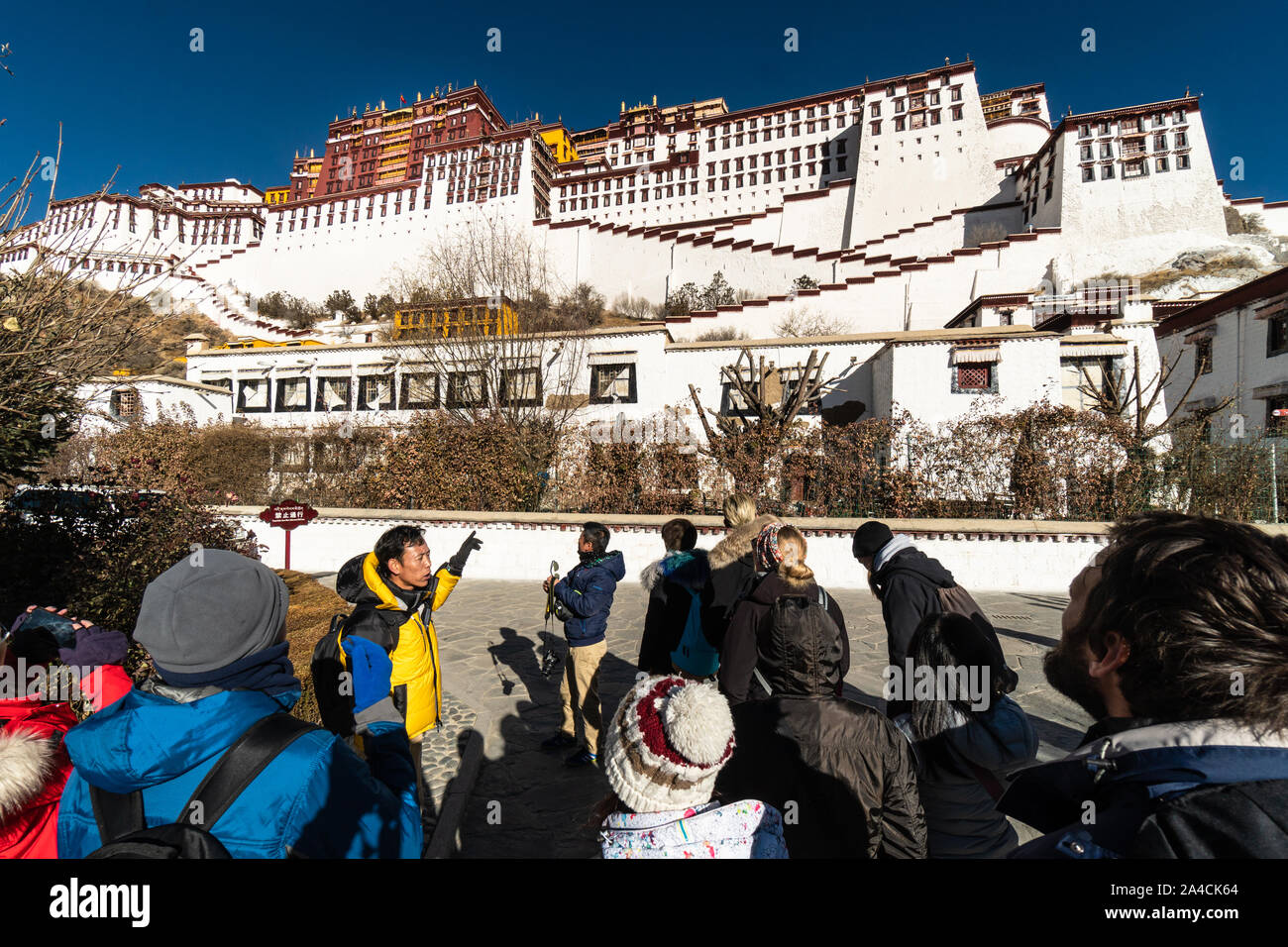 Lhasa, China - 13. Dezember 2018: Internationale Touristen zu Ihren Reiseleiter zu hören der Potala Palast im Herzen der Altstadt von Lhasa in Tibet pro Stockfoto