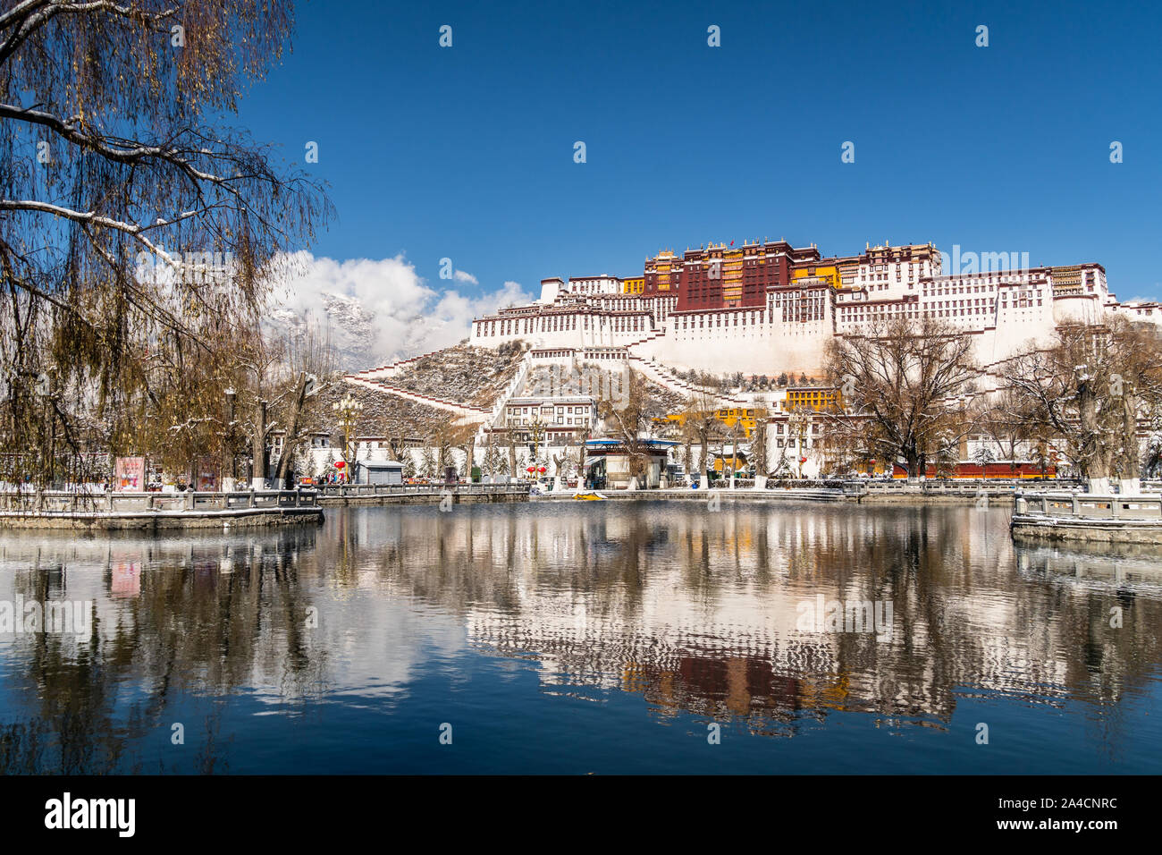 Atemberaubende Aussicht und Reflexion des berühmten Potala Palast im Herzen von Lhasa in Tibet in der Provinz in China an einem sonnigen Wintertag mit Schnee mout abgedeckt Stockfoto